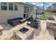 Stone outdoor kitchen featuring built-in grill, cooking space, seating, and a fire pit at 7740 Nesbit Ferry Rd, Atlanta, GA 30350