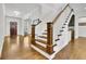 Hardwood staircase with white risers and dark wood banister, creating an elegant transition between floors at 7740 Nesbit Ferry Rd, Atlanta, GA 30350