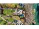 A bird's eye view of a luxury home with a pool and landscaped yard leading to the lake at 1525 Lockridge Dr, Cumming, GA 30041