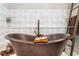 Close up view of a soaking tub with wood accents, and tile walls at 1525 Lockridge Dr, Cumming, GA 30041
