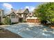 Traditional two-story home with brick, a three-car garage, and a large concrete driveway at 1525 Lockridge Dr, Cumming, GA 30041