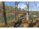 A quaint lakeside view in the woods featuring a dock and calm, green water at 1525 Lockridge Dr, Cumming, GA 30041