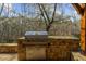 Built-in outdoor grill featuring stone surround and stainless steel appliances at 1525 Lockridge Dr, Cumming, GA 30041