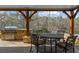 Outdoor kitchen with a built-in grill, stone countertops, and wrought iron seating at 1525 Lockridge Dr, Cumming, GA 30041