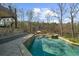 Sparkling swimming pool with a built-in spa and stone decking overlooking a wooded area at 1525 Lockridge Dr, Cumming, GA 30041