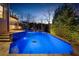The LED-lit pool features vibrant blue lighting, surrounded by a stone patio and landscaped gardens at 1525 Lockridge Dr, Cumming, GA 30041