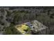 Aerial view of a wooded lot with a charming brick home and a large well-kept lawn on a sunny day at 2415 Bankstone Sw Dr, Marietta, GA 30064