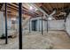 Unfinished basement with exposed ceiling, brick wall, concrete floor, and stairs, offering potential for customization at 2415 Bankstone Sw Dr, Marietta, GA 30064