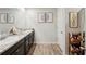 Bathroom featuring dual sinks, dark cabinets, and wood-look flooring at 3464 Enterkin Ln, Atlanta, GA 30349