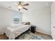 Cozy bedroom featuring a ceiling fan, neutral walls, a window and a comfortable bed with soft patterned pillows at 3464 Enterkin Ln, Atlanta, GA 30349