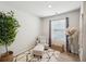 Bright sitting room featuring a comfortable chair, accent table, large window and a decorative tree in a basket at 3464 Enterkin Ln, Atlanta, GA 30349