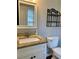 Cozy bathroom featuring granite countertop, white cabinets, decorative mirror, and black shelving at 988 Old Holcomb Bridge Rd, Roswell, GA 30076
