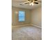 A neutral colored carpet fills the spacious bedroom with a ceiling fan and one window at 988 Old Holcomb Bridge Rd, Roswell, GA 30076