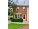 Charming brick townhouse featuring a well-manicured lawn and vibrant red front door at 988 Old Holcomb Bridge Rd, Roswell, GA 30076