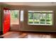 Bright living room featuring large windows, hardwood floors, and a red front door at 988 Old Holcomb Bridge Rd, Roswell, GA 30076