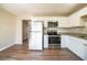 Bright kitchen features stainless steel appliances, granite countertops, white cabinetry, and wood flooring at 4205 Whittier Ct, Decatur, GA 30034