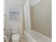 Bathroom with a white bathtub and a shower with beige tiling and a window with blinds at 4540 Hastings Dr, Cumming, GA 30041