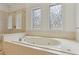 Bathroom featuring soaking tub and shower with elegant tile work and decorative windows at 4540 Hastings Dr, Cumming, GA 30041