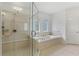 Bathroom with soaking tub, separate shower, and decorative windows at 4540 Hastings Dr, Cumming, GA 30041