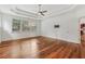 A bedroom with wood floors, white walls, and a tray ceiling with a fan and large window to let in natural light at 4540 Hastings Dr, Cumming, GA 30041