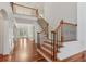 Grand foyer with a staircase featuring decorative wrought iron and wood railing and gleaming hardwood floors at 4540 Hastings Dr, Cumming, GA 30041