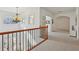 Hallway with wood and wrought iron banister, arched window, and carpeted floor at 4540 Hastings Dr, Cumming, GA 30041