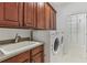 Spacious laundry room with built-in cabinets, a utility sink, and a modern washer and dryer set at 4540 Hastings Dr, Cumming, GA 30041