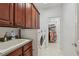A laundry room with ample cabinet space, a sink, and a doorway leading to a closet at 4540 Hastings Dr, Cumming, GA 30041