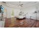 Bright main bedroom features hardwood floors, a fan, and ample natural light at 4540 Hastings Dr, Cumming, GA 30041
