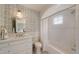 Elegant bathroom featuring a modern vanity, decorative wallpaper and a shower/tub with arched subway tile surround at 46 Montclair Ne Dr, Atlanta, GA 30309