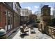 Charming stone patio featuring outdoor seating, a stone fireplace, and a beautiful view of the landscaped backyard at 46 Montclair Ne Dr, Atlanta, GA 30309
