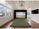 Spacious recreation room featuring a golf simulator, large windows, hardwood floors, and stylish lighting at 46 Montclair Ne Dr, Atlanta, GA 30309