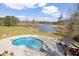 Aerial view of the pool, overlooking a lake, and surrounded by a large yard with mature trees at 5168 Parkview Rd, Social Circle, GA 30025