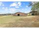 An outdoor view of a barn and tractor barn, nestled in a wide open space, showcasing country charm at 5168 Parkview Rd, Social Circle, GA 30025