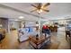 Open basement with a kitchen, pool table, and a seating area illuminated by a vintage ceiling fan at 5168 Parkview Rd, Social Circle, GA 30025
