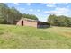 A horse barn exterior is situated in a grassy field, offering ample space for equestrian activities and animal care at 5168 Parkview Rd, Social Circle, GA 30025