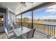 Charming covered patio with ceiling fan overlooking a serene lake view and outdoor seating at 5168 Parkview Rd, Social Circle, GA 30025