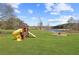 A playground in the backyard creates a perfect space for outdoor fun, situated on a large grassy lawn near the water at 5168 Parkview Rd, Social Circle, GA 30025