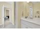 Bright bathroom featuring a white vanity, framed mirror, and neutral walls with doorway to another room at 812 Newsome Nw Aly, Marietta, GA 30064