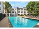 Exterior swimming pool with lounge seating, landscaping, and community buildings in the background at 821 Ralph Mcgill Ne Blvd # 2210, Atlanta, GA 30306
