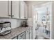 Convenient butler's pantry with granite countertops and gray cabinetry at 187 Still Pine Bnd, Smyrna, GA 30082