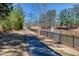 Picturesque walking path with a metal fence bordering a serene pond with a fountain at 187 Still Pine Bnd, Smyrna, GA 30082