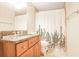 This bathroom has wood cabinets with a granite countertop and a shower/tub with a cactus-themed curtain at 2479 Peachtree Ne Rd # 1606, Atlanta, GA 30305