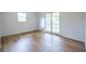 This bedroom features a light-filled window, wood-look floors, and a door leading to a private balcony at 5384 Blackhawk Dr, Acworth, GA 30102