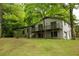 Two-story house with white painted brick, wooden deck, and lush trees surrounding the home at 5384 Blackhawk Dr, Acworth, GA 30102