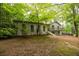 Two-story house with white painted brick and arched doorway, surrounded by lush, mature trees at 5384 Blackhawk Dr, Acworth, GA 30102