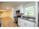 Updated kitchen with stainless steel appliances, white cabinets, and wood flooring at 5384 Blackhawk Dr, Acworth, GA 30102