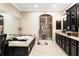 A full bathroom with granite countertops, dark cabinetry, jacuzzi tub, and glass shower stall at 2130 Monhegan Se Way # 11, Smyrna, GA 30080