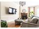 Open living room with wood floor, fireplace, large TV, and view to the outdoor patio at 2130 Monhegan Se Way # 11, Smyrna, GA 30080