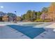 View of a tennis court and covered community pool surrounded by green trees at 2382 Gallard St, Lawrenceville, GA 30043